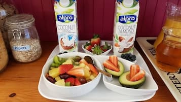 Ein Frühstückswagen mit Obst, zwei Kartons Alpro Kokos-Mandelmilch, ein Glas Alpenmüsli und eine Karaffe Saft.