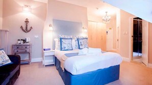 A bedroom with a large bed, bedside tables, a dresser, and a chandelier. - Number 61 Guest House and Tea Room (North Shields)