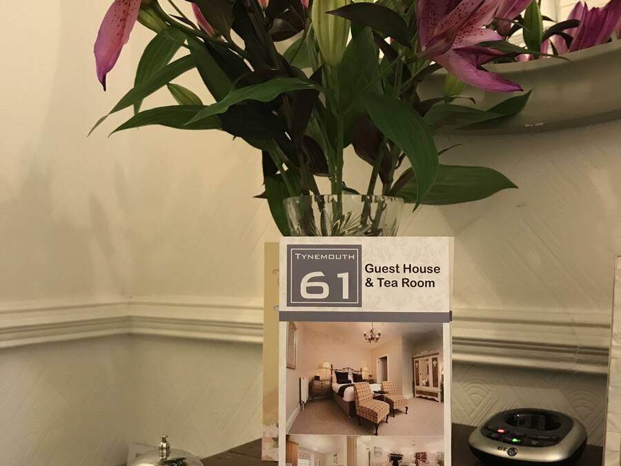 A brochure for a guest house and tea room with a floral arrangement on a table.