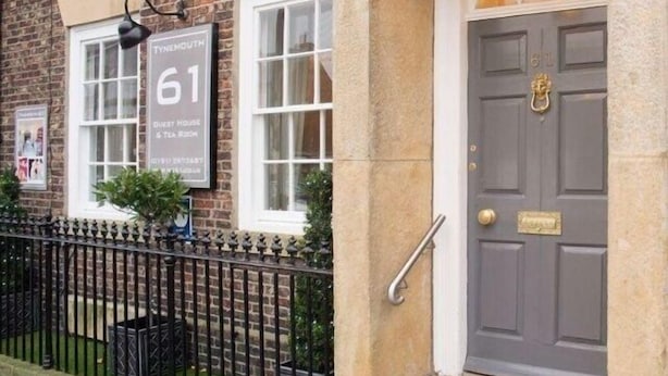 A building with a sign reading "61" and "Guest House & Tea Room". - Number 61 Guest House and Tea Room (North Shields)