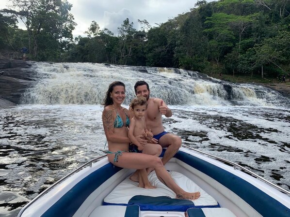 A family on a boat near a waterfall. - Pousada Lagoa do Cassange (Maraú)
