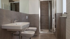 A modern bathroom with a sink, toilet, and shower.