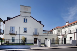 A two-story building with a white facade, balconies, and a small tower-like structure on the roof. - Residence Le Querce Monza (Monza)