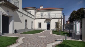 A courtyard with a cobblestone pathway leading to a building entrance.