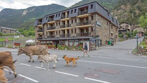 Un bâtiment en pierre doté de nombreux balcons et abritant au rez-de-chaussée un restaurant appelé « Restaurant Arans ».