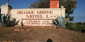 A sign for Orange Grove Motel L, indicating it is a caravan and camping park. - Orange Grove Motel (Chinhoyi)