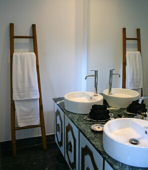 A bathroom with two sinks, a mirror, and a towel rack.