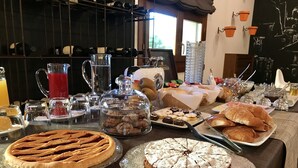 Un bufé de desayuno con diversos pasteles, tortas y bebidas.