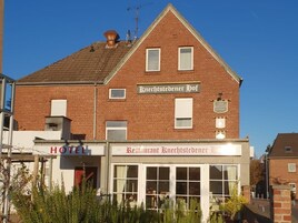 Un edificio de dos pisos con un letrero que dice 'Hotel Knechtstedenner Hof' y 'Restaurante Knechtstedenner Hof'.
