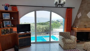 Una sala de estar con televisor, sofá, mesa de centro y chimenea.