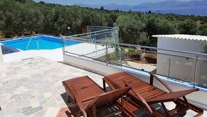 Una piscina con vistas despejadas al mar y montañas al fondo.
