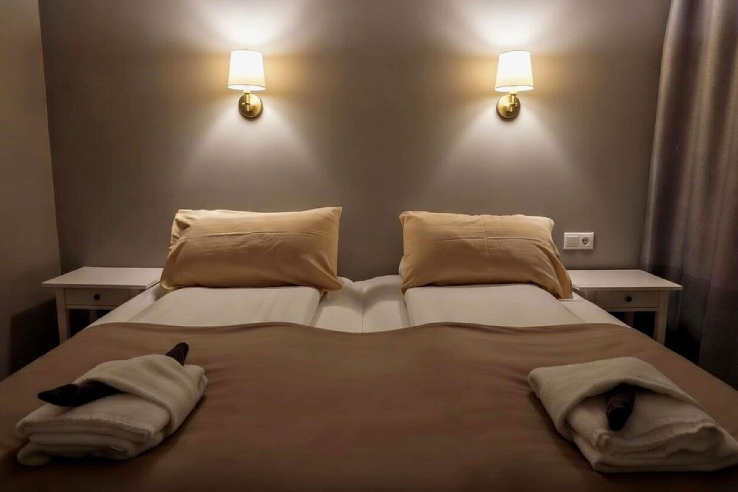 A double bed with two nightstands, each with a lamp.