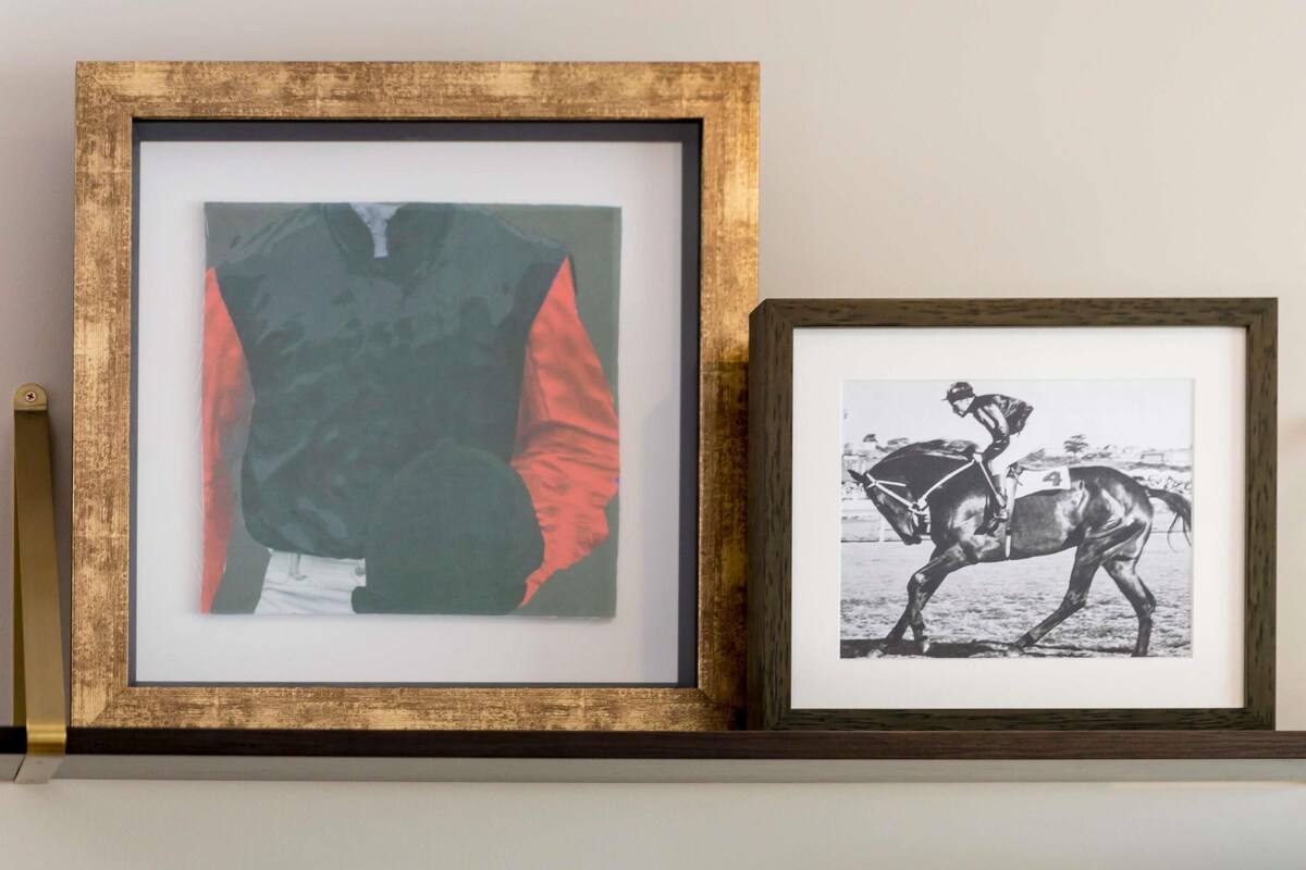 Two framed pictures on a shelf.