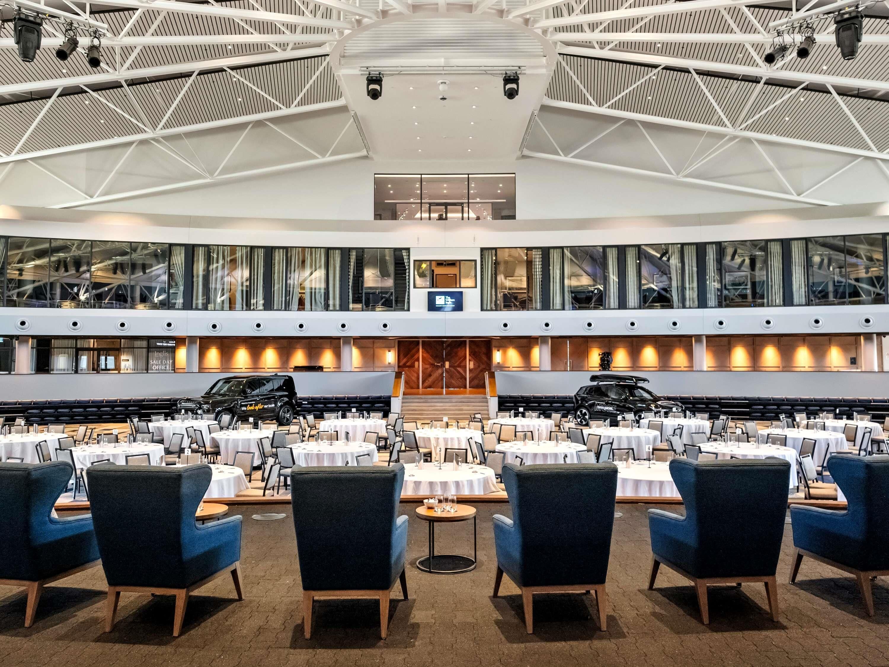 Un salón de conferencias amplio con techos altos, ventanas grandes y un diseño arquitectónico moderno.