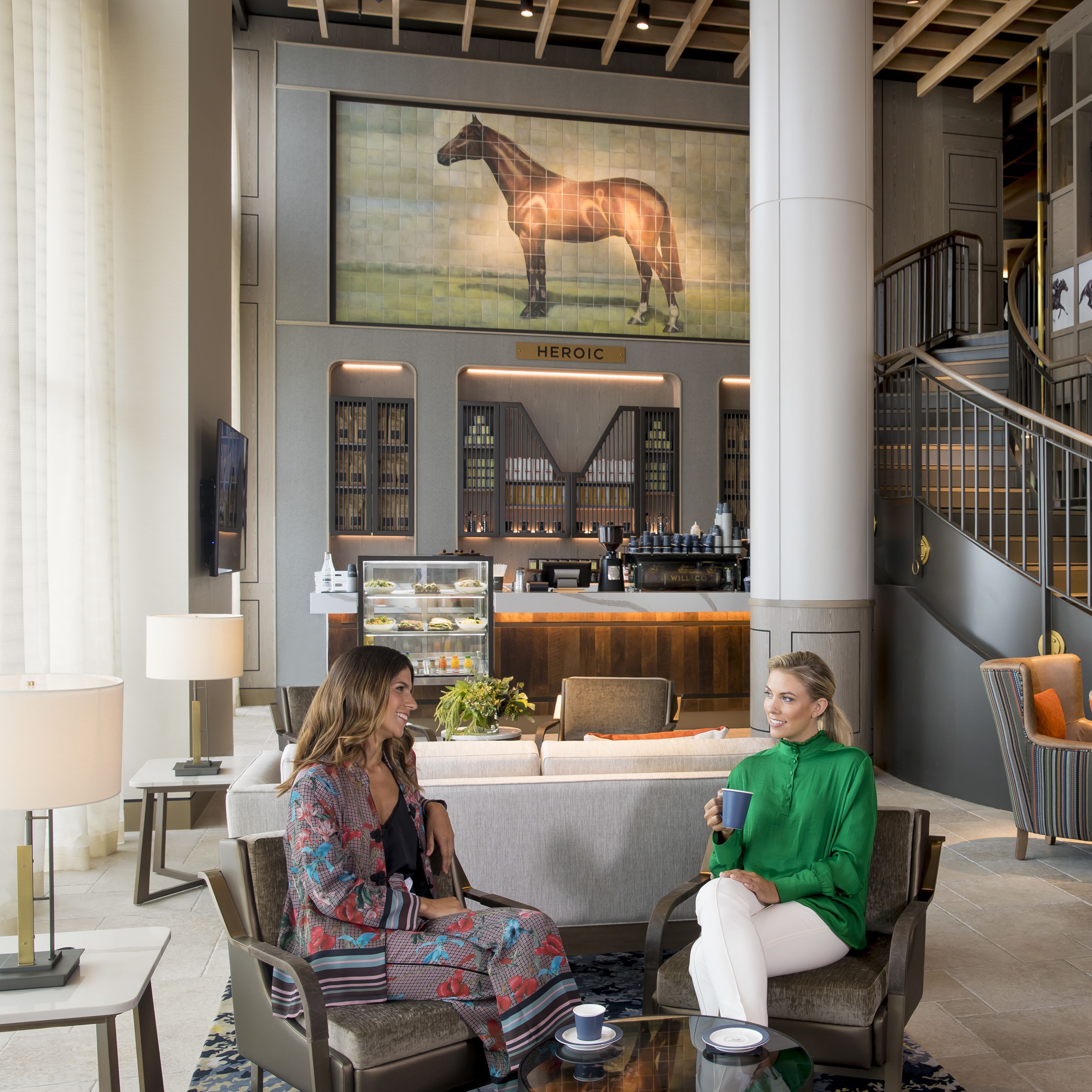 A lobby with a bar area, seating, and a staircase.