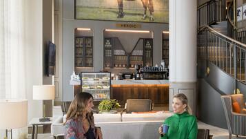 A lobby with a bar area, seating, and a staircase.