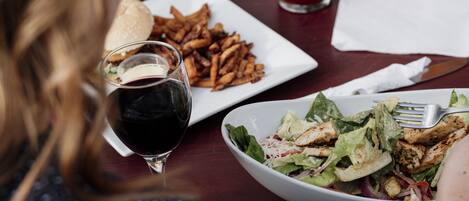 Una mesa con un plato de papas fritas, una hamburguesa y una ensalada.