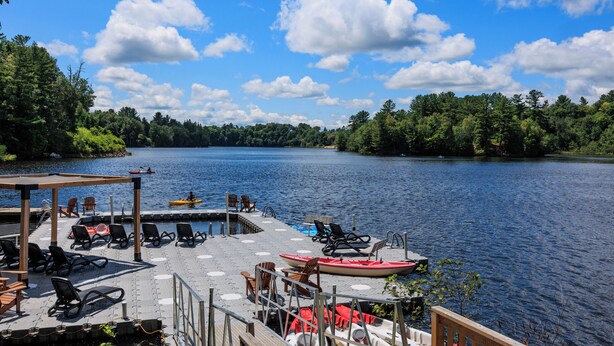A lakeside dock with chairs and a kayak, surrounded by trees and a clear sky. - Rawdon Golf Resort (Rawdon)