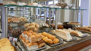 A buffet with various baked goods and pastries. - Hotel Galo Vermelho (Gramado)