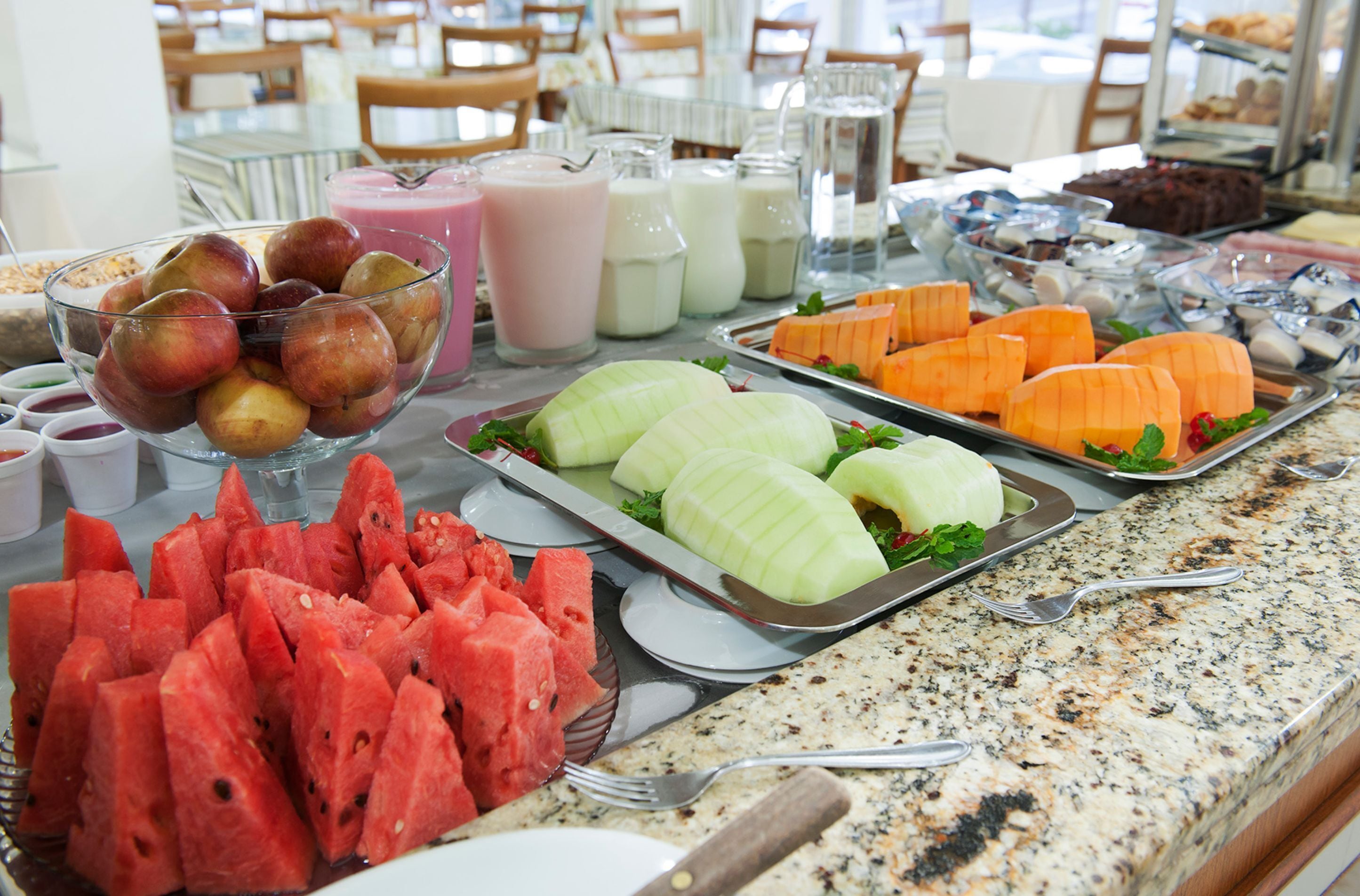 Un bufé con diversas frutas, verduras y bebidas.