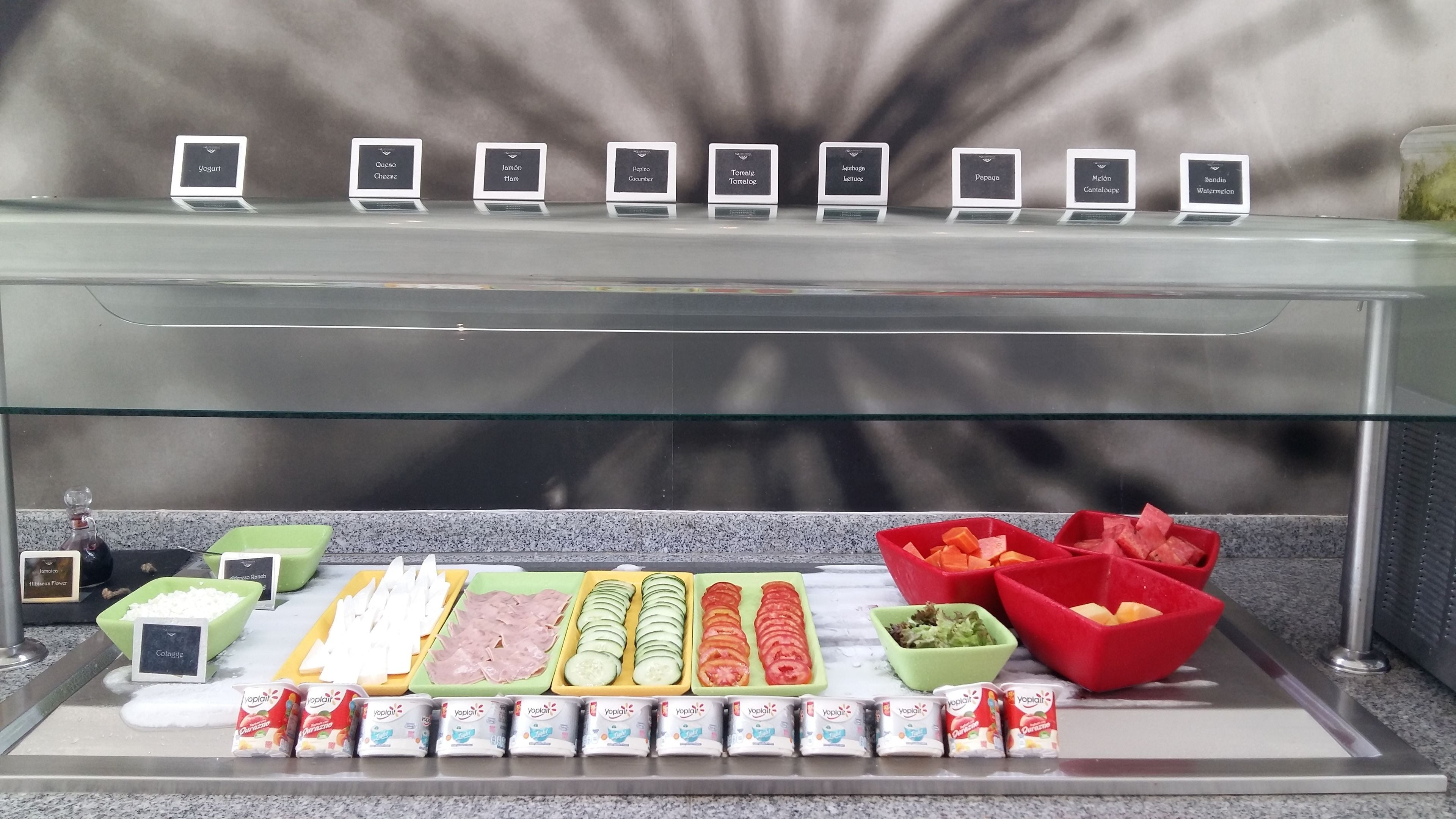 Een buffet met diverse gerechten en gemarkeerde bakken.