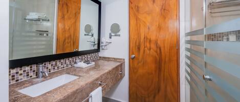 A bathroom with two sinks, a large mirror, and wooden doors.