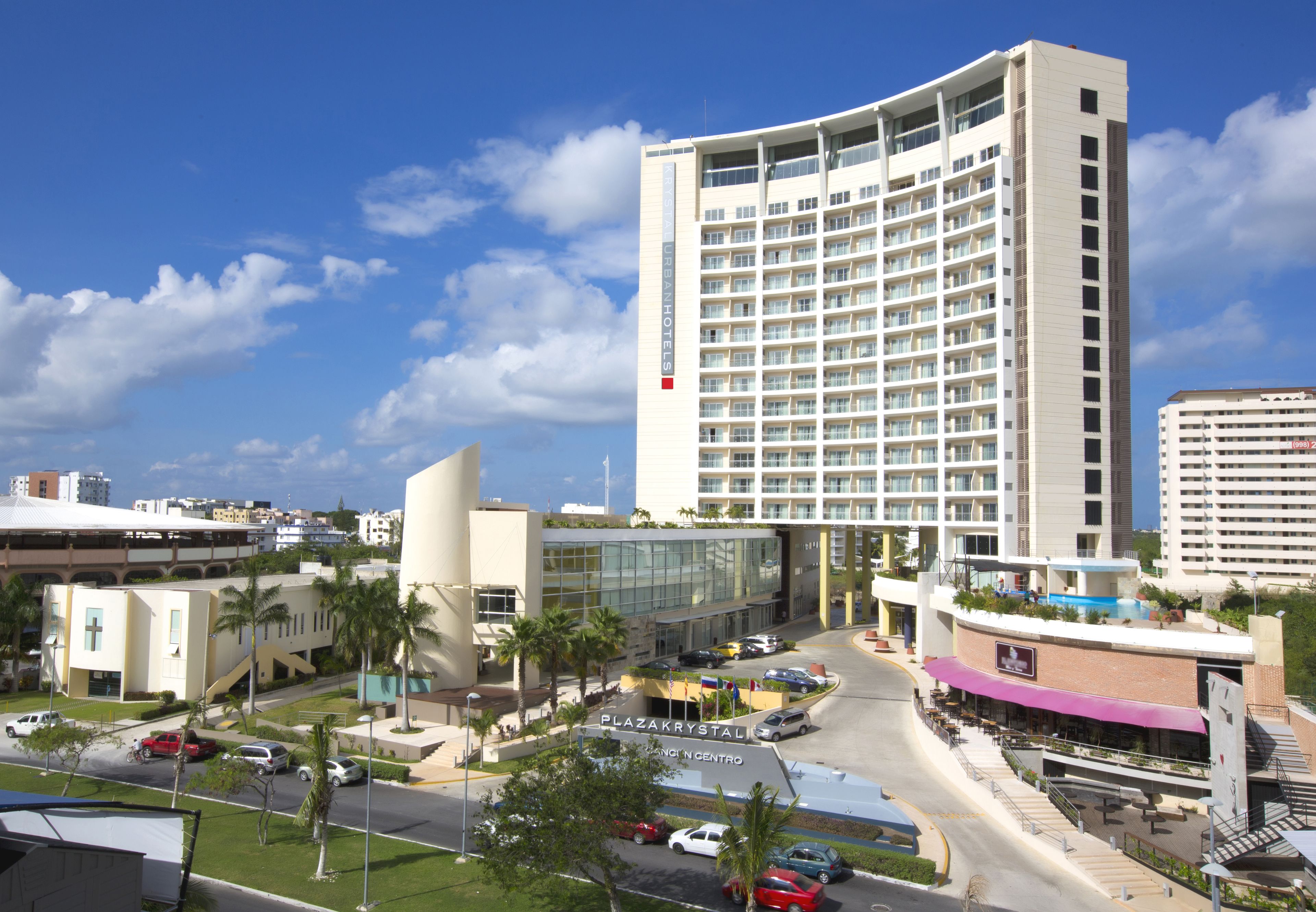 A high-rise hotel with a modern design, featuring a central atrium and multiple balconies.