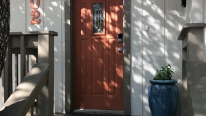 A wooden door with a window, a large blue planter, and a wooden staircase leading to the entrance. - The Blanco River is calling your name!! Come and enjoy!! (Wimberley)