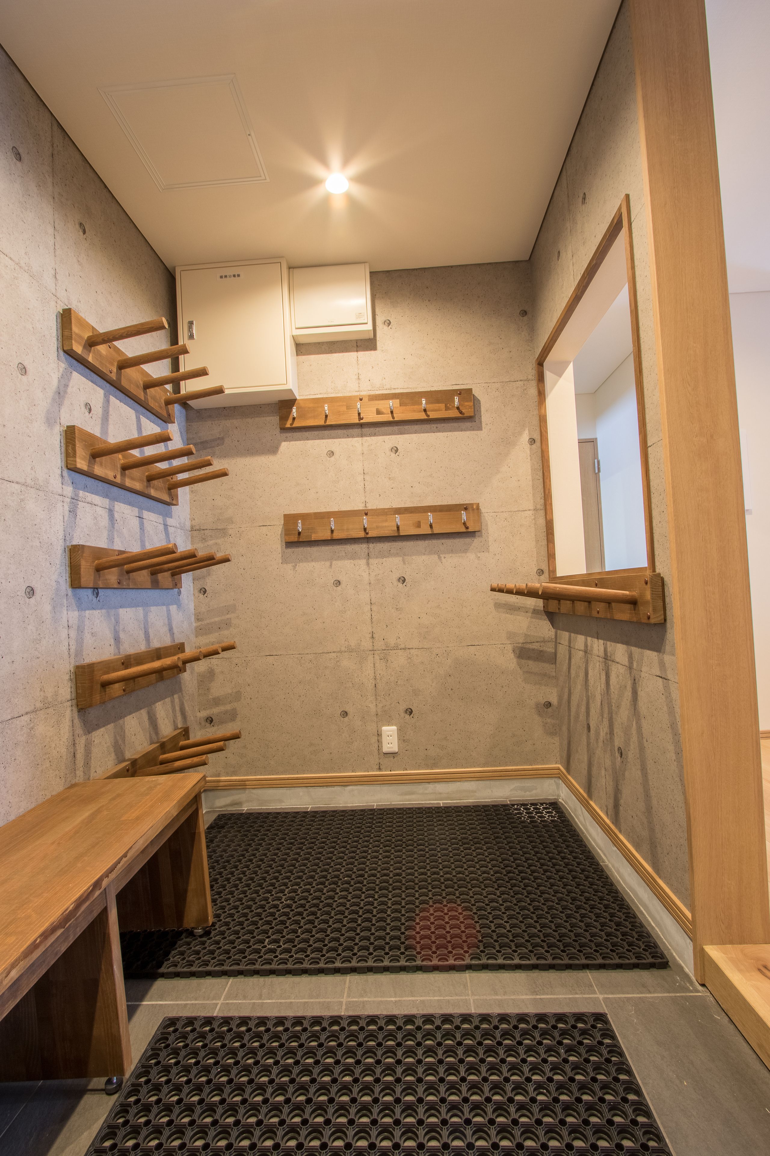 Une salle de bain avec des porte-serviettes en bois, un espace douche et un sol carrelé.