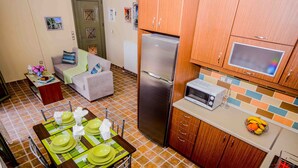 A compact kitchen with a refrigerator, microwave, and tiled backsplash. - #1-Clean, self catering 2 bedroom apartment with large balcony and free parking (Antipata)