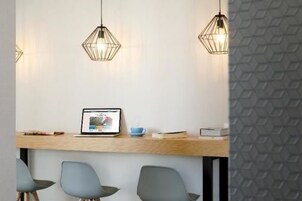 Un espacio de oficina moderno con un escritorio de madera, una computadora portátil y tres sillas.