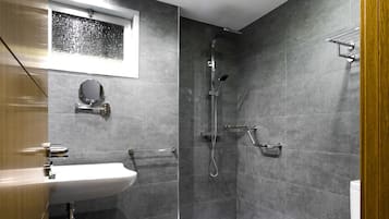 A modern bathroom with a shower, toilet, and sink.