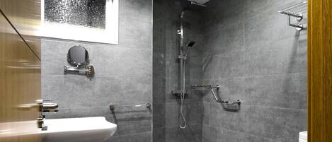 A modern bathroom with a shower, toilet, and sink.