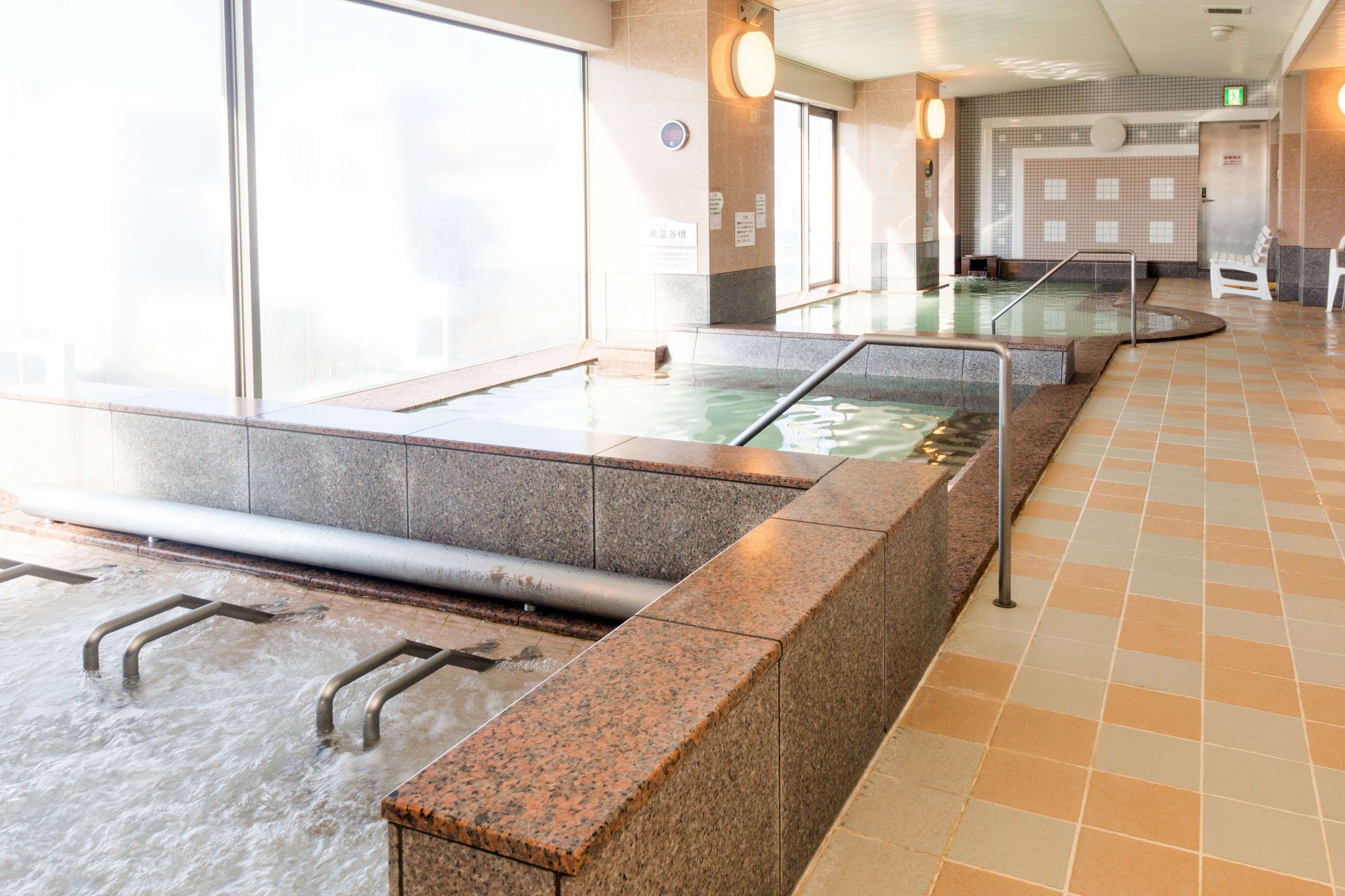 A spa area with a hot tub, seating, and a tiled floor.