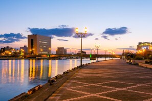 A waterfront promenade with a paved walkway, street lamps, and a bridge in the background. - HOTEL GLOBAL VIEW KUSHIRO (Kushiro)