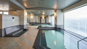 A swimming pool area with tiled flooring, benches, and a glass railing. - HOTEL GLOBAL VIEW KUSHIRO (Kushiro)