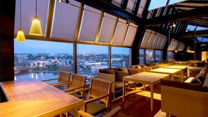 A modern interior with wooden furniture, large windows, and a city view. - HOTEL GLOBAL VIEW KUSHIRO (Kushiro)