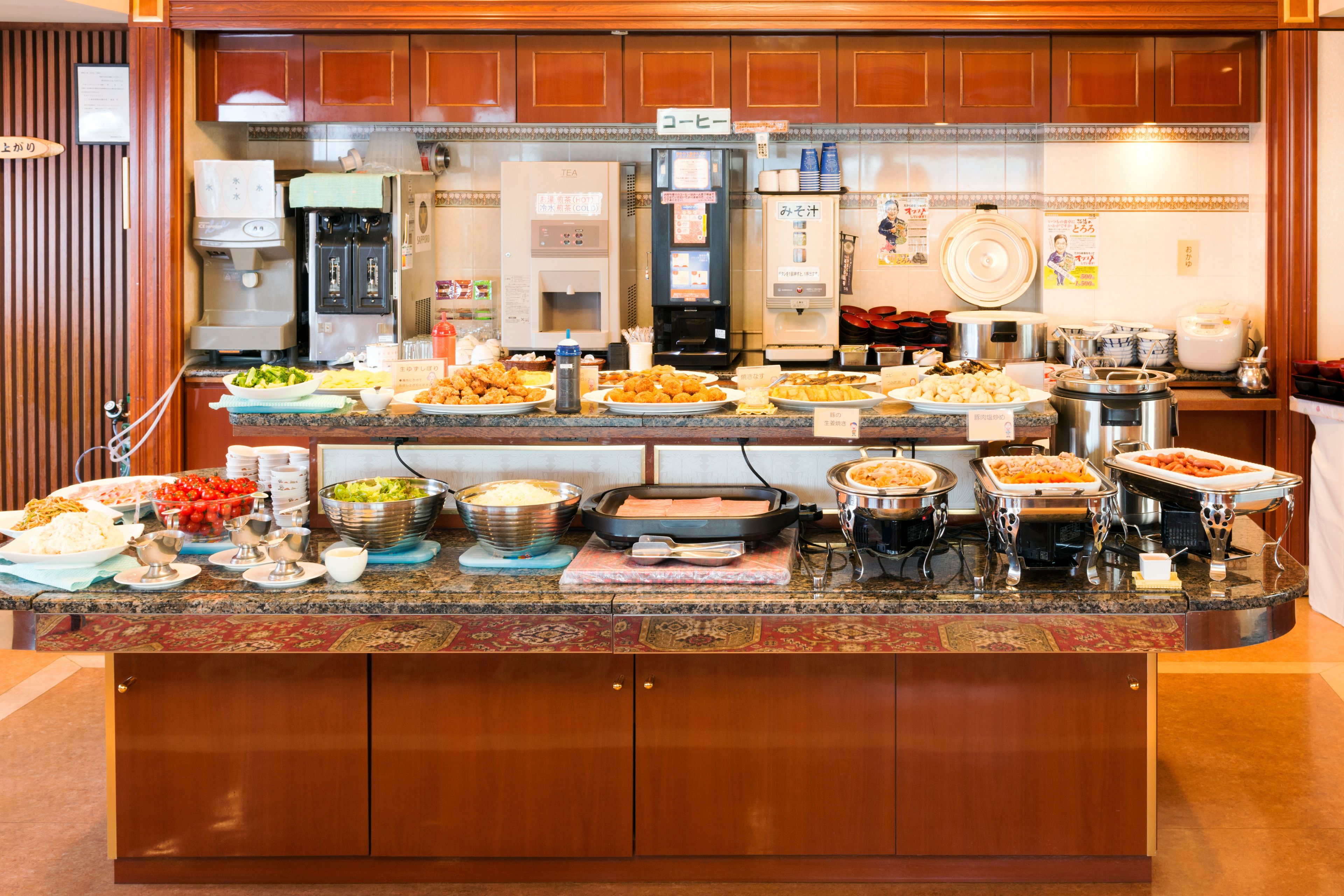 A buffet with various dishes and a coffee machine.
