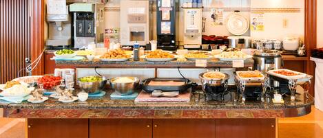 A buffet with various dishes and a coffee machine.