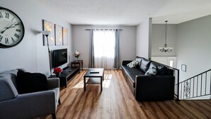 A modern living room with a sofa, a coffee table, and a TV.