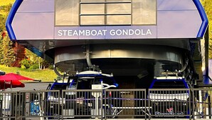 A steamboat gondola with the name "STEAMBOAT GONDOLA" visible on its side.