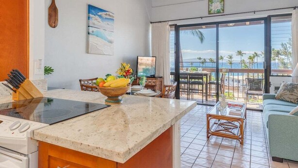 Una cocina con una isla grande, un comedor con vistas y una sala de estar con sofá.