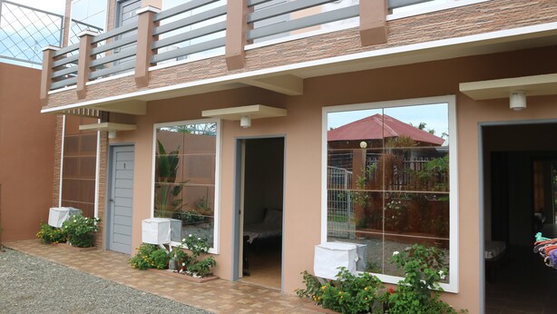 A two-story residential building with a balcony, large windows, and a tiled entrance. - Brown Epitome Lodge (Baler)