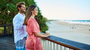 A couple standing on a wooden deck overlooking a beach. - The Country House at Hunchy Montville (Hunchy)
