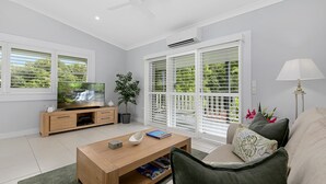 A modern living room with a flat-screen TV, wooden coffee table, and a sofa. - The Country House at Hunchy Montville (Hunchy)