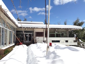 A modern building with a snow-covered roof and large windows. - Amanohashidate Youth Hostel (Miyazu)