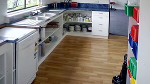 Une cuisine avec un long comptoir, un évier et une fenêtre.