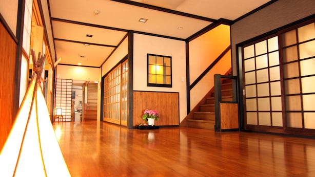 A traditional Japanese interior with wooden flooring, sliding doors, and a staircase.