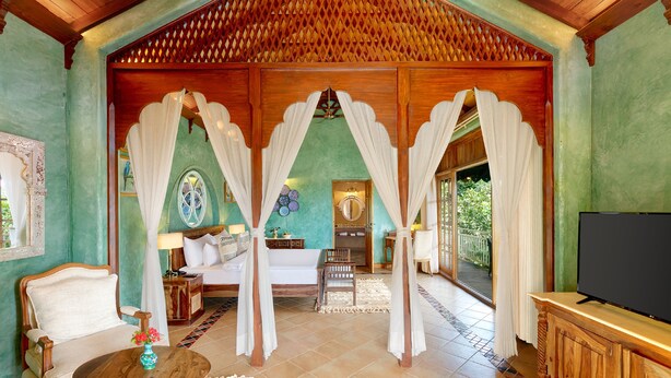 Una habitación amplia con una cama grande, televisión y vistas al exterior.