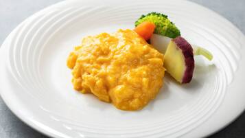 A white plate with a serving of macaroni and cheese, broccoli, and a slice of red potato.